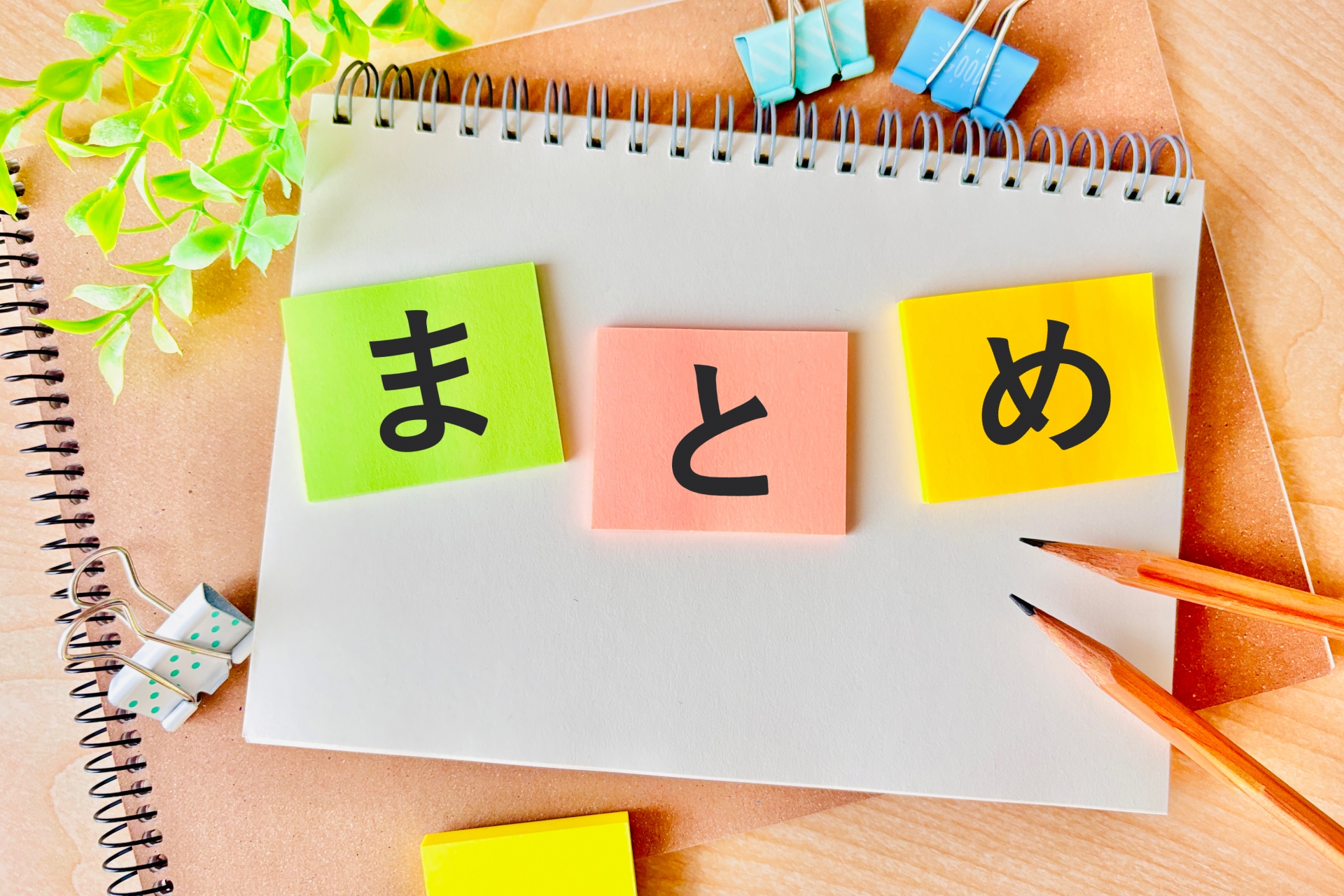 「まとめ」と書かれたカラフルな付箋と鉛筆が置かれたノート