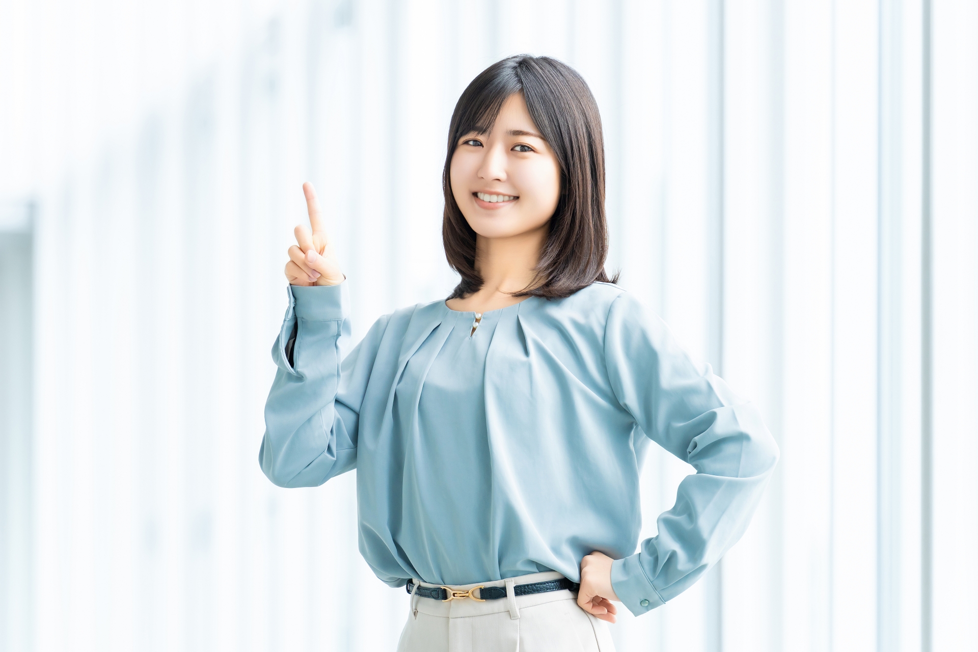 指差しで利点を示す女性のイメージ写真
