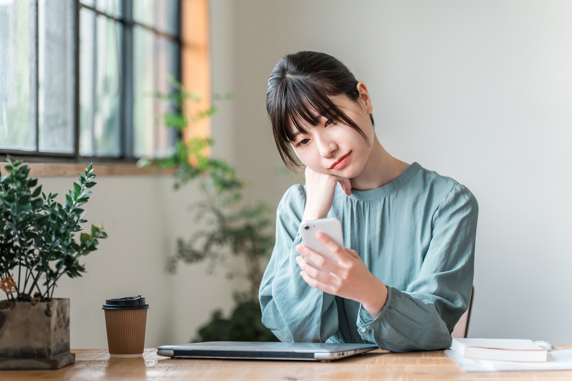 スマホを見て首をかしげる女性